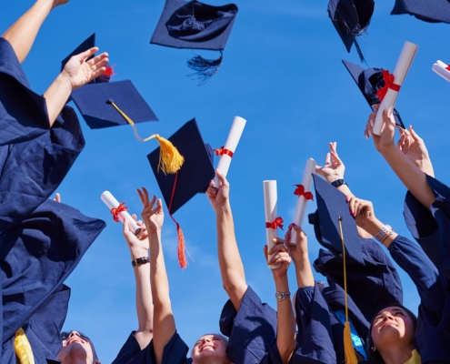 Image of graduating students throwing their caps in the air
