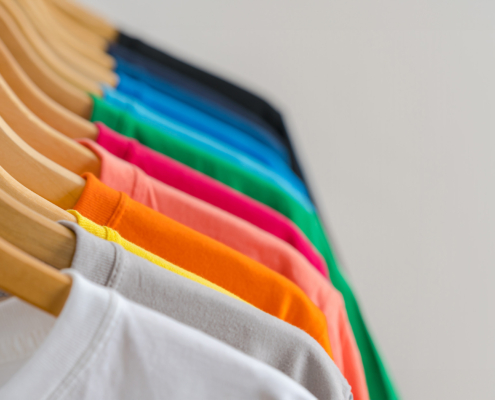 Front view of a rack of multicolored plain shirts