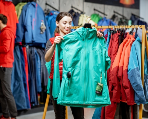 person picking out windbreaker in store