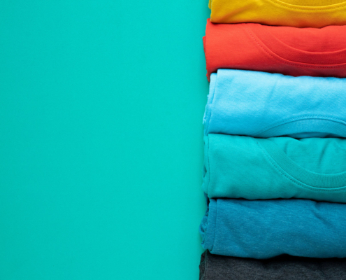 close up of rolled colorful clothes on green background