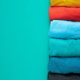 close up of rolled colorful clothes on green background
