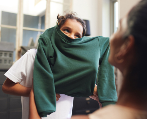 Boy with school jumper stuck on his head