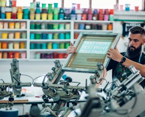 Male worker preparing screen printing film in a workshop